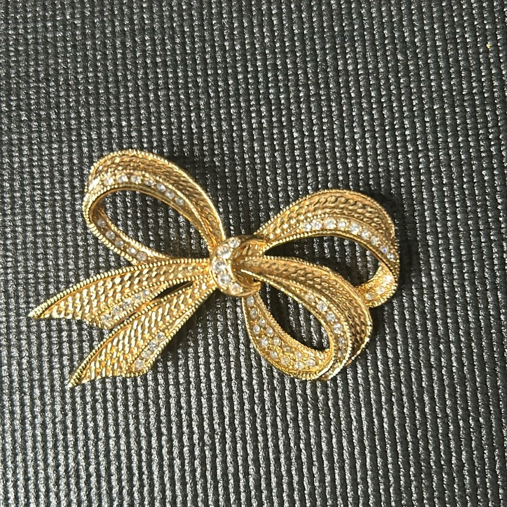 Roman gold tone and rhinestone bow brooch